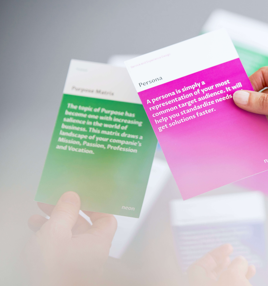 a female hand is holding one of "neons method cards", that explains how to do Personas