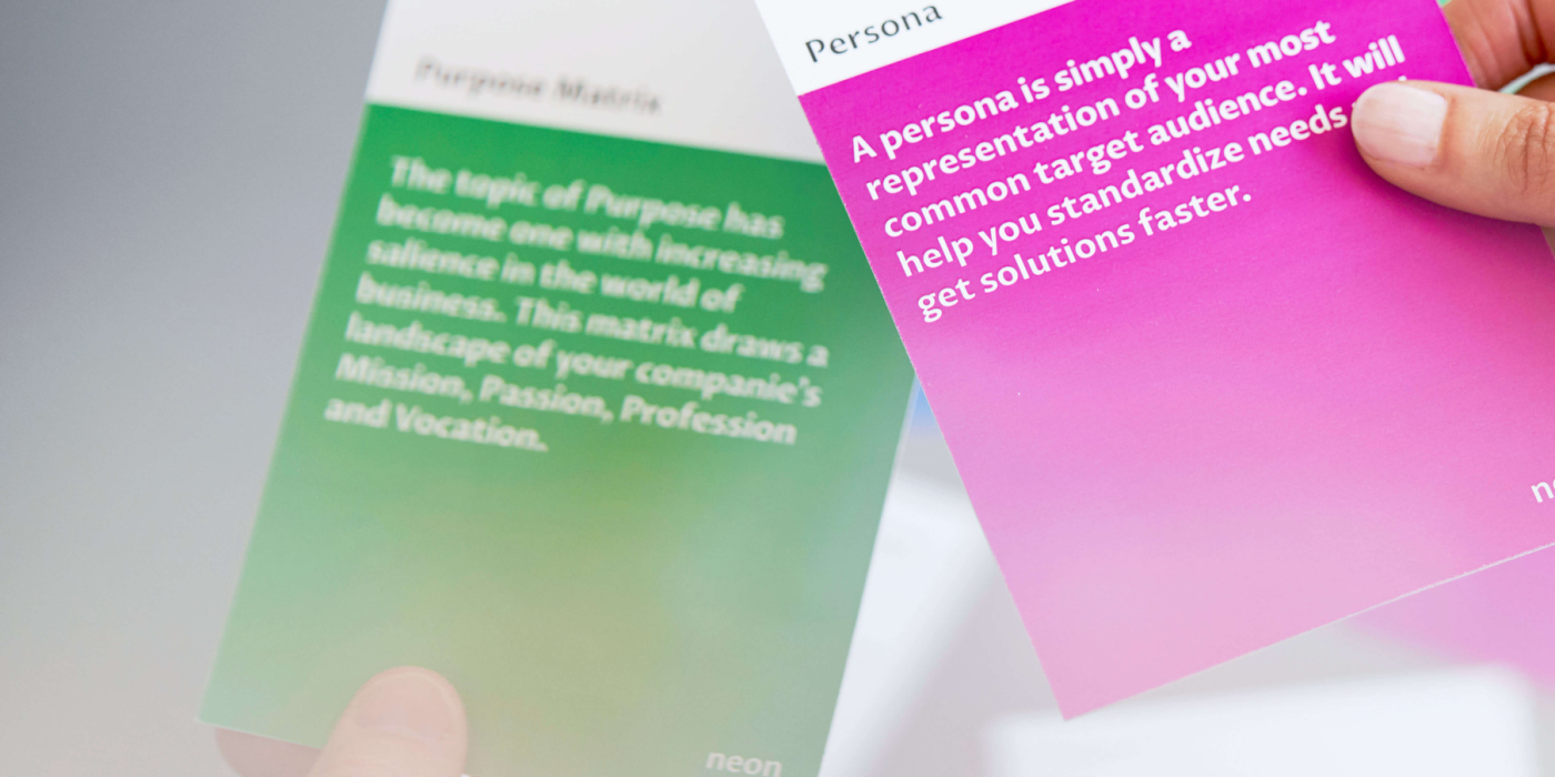 a female hand is holding one of "neons method cards", that explains how to do Personas